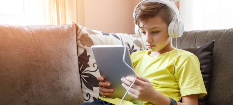Un niño experimenta las ventajas de los audiolibros escuchándolos en una tableta